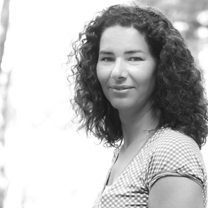 Zwart-wit foto van vrouw met donker krullend haar tot de schouder (Mariska Visscher).